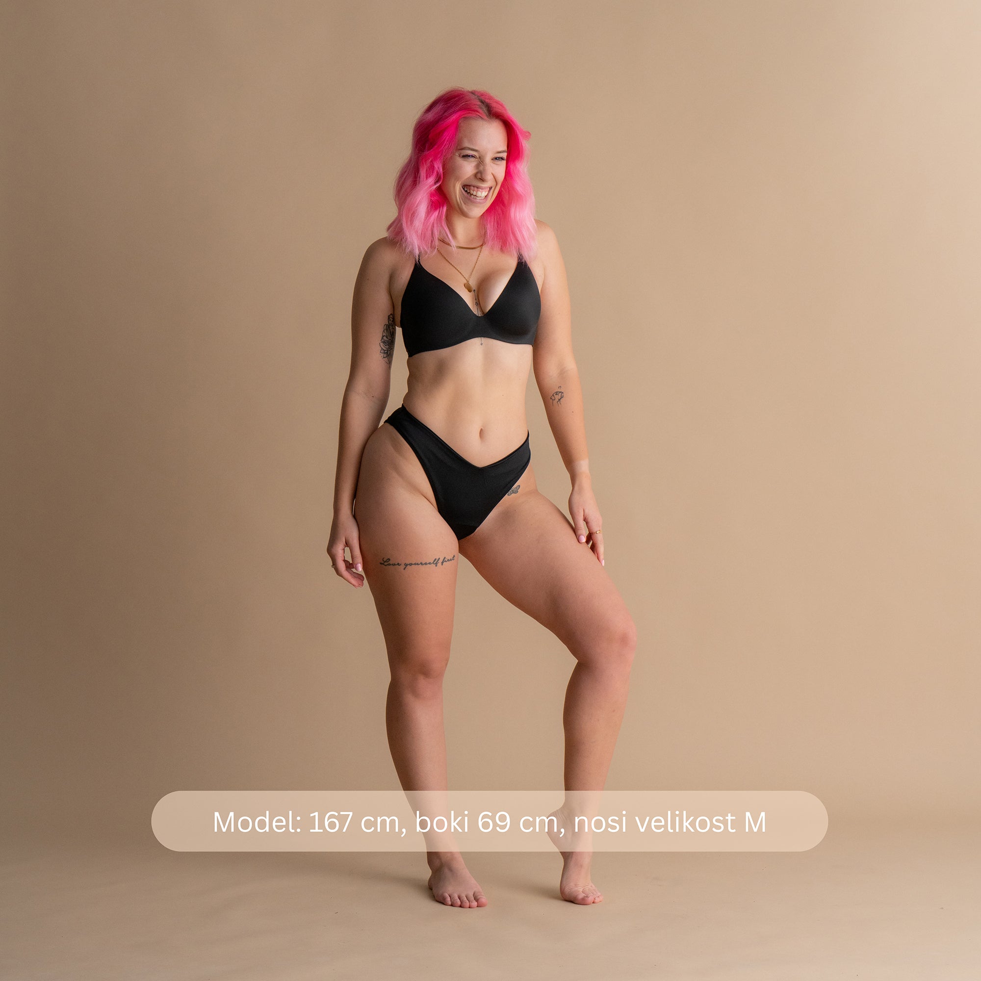 Celoten pogled spredaj v črni barvi – Model na tej sliki nosi črne bikini hlačke Leakproof Period Swim z diskretno, vgrajeno zaščito, ki zagotavlja udobje in zaupanje. Bikini hlačke nudijo ženstven in eleganten kroj ter zagotavljajo zaščito pred morebitnimi uhajanji med plavanjem.