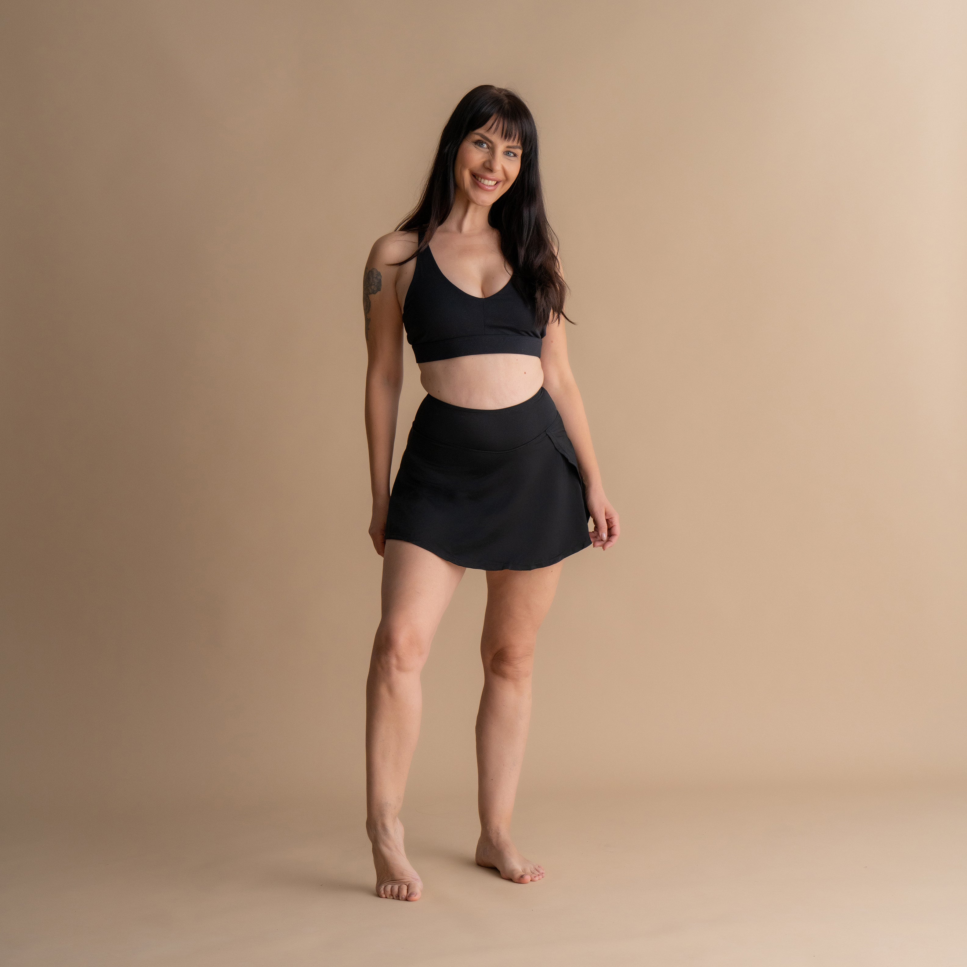 full body Front View of a model wearing the Leakproof Period Swim Skirt paired with a matching bikini top. The swim skirt provides discreet, built-in period protection while offering a flattering and comfortable design for swimming, sunbathing, or strolling.