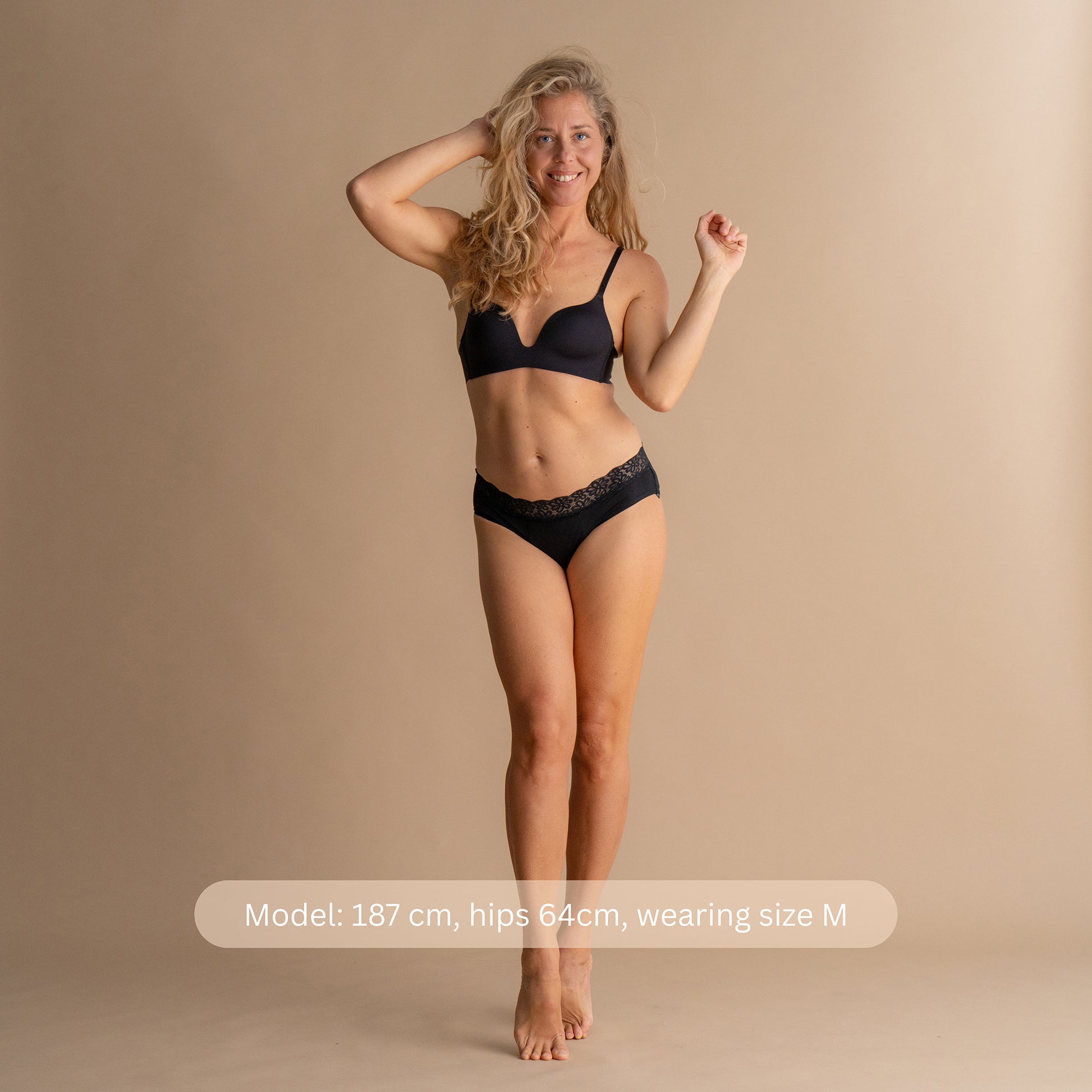 Full body front view of a model wearing the Leakproof Soft Cotton Brief in black, showcasing the soft lace design and comfortable fit. The model is 187 cm tall with hips 64 cm, wearing size M.