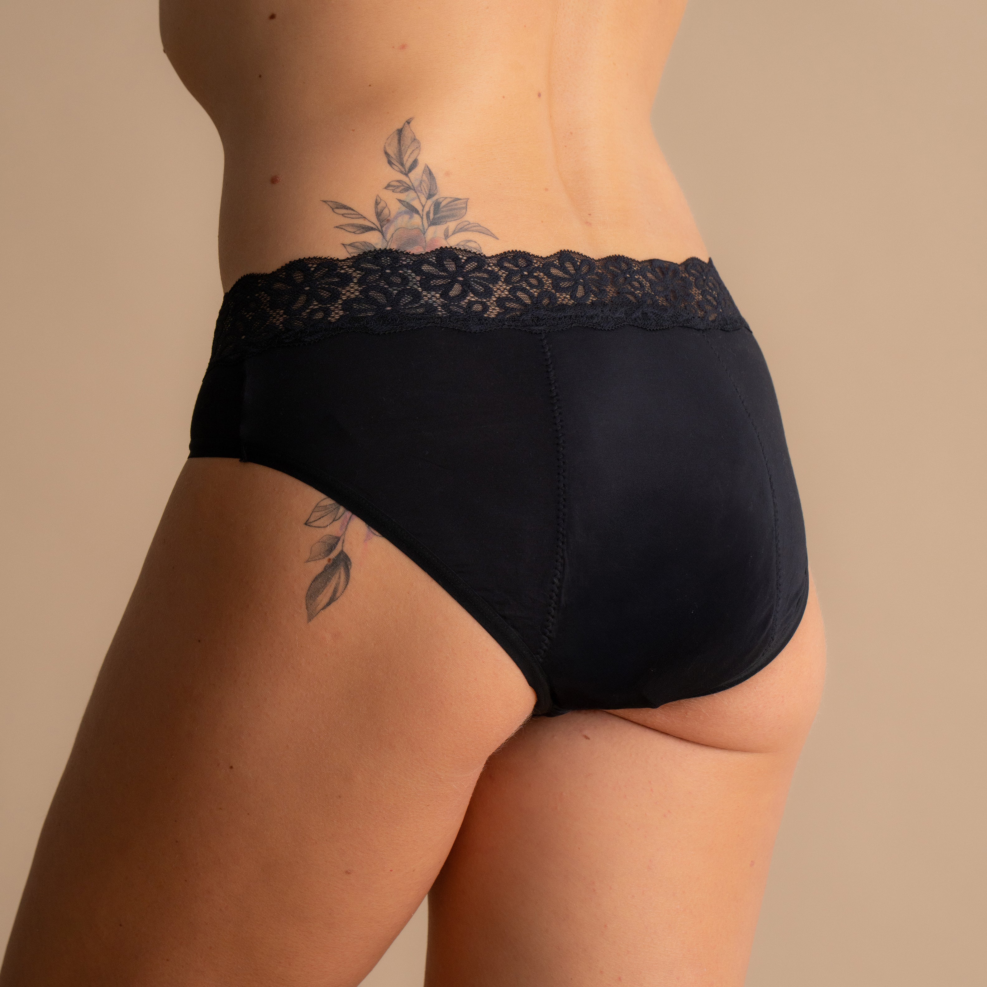 Back view of the Leakproof Soft Cotton Brief in black, featuring a delicate lace waistband and soft cotton fabric for ultimate comfort, with breathable and discreet protection.