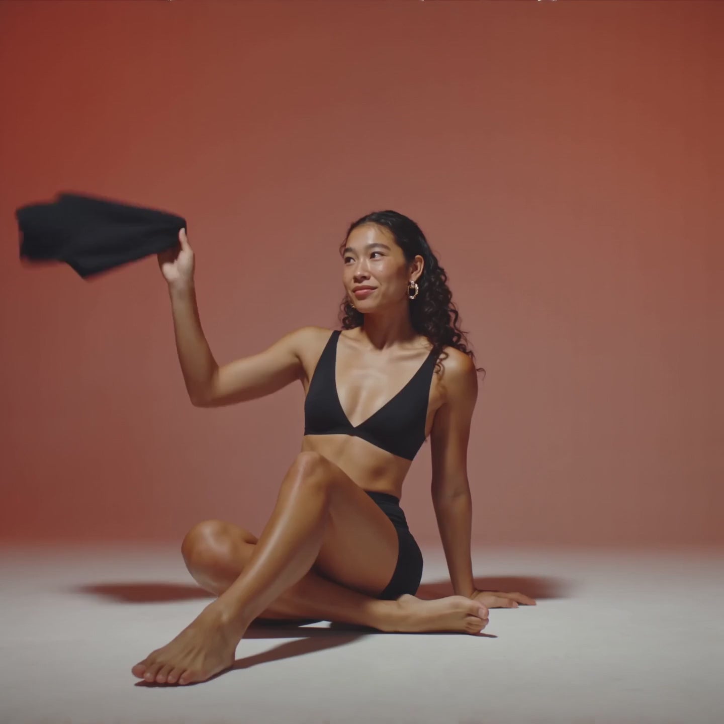 Load video: Slow cinematic video showing hands touching soft fabric, natural textures, and Floena product details.